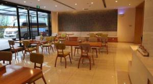 a dining room with tables and chairs in a restaurant at 7 Days Premium Chongqing Longtou Temple North Railway Station Center in Chongqing