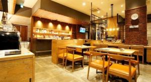 a restaurant with tables and chairs and a bar at APA Hotel Chiba Inzaimakinohara-Ekimae in Chiba-nyūtaun