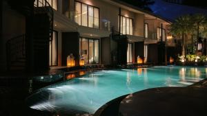 ein großes Schwimmbecken vor einem Gebäude bei Nacht in der Unterkunft Luminous Resort & Spa by Areca in Phuket