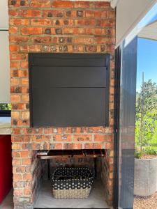 een stenen open haard met een televisie erop bij EersteBosch Cottages in Stellenbosch