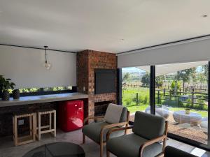 een woonkamer met open haard en tv bij EersteBosch Cottages in Stellenbosch