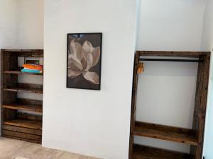 een kamer met een witte muur met een afbeelding van een bloem bij EersteBosch Cottages in Stellenbosch