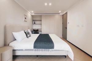 ein Schlafzimmer mit einem großen Bett in einem Zimmer in der Unterkunft EHUB - Nanjing Road 2Bedroom Apartment in Shanghai + 2 Fotos