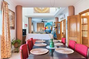 a dining room with a table and red chairs at La pincelada de Mágina in Bedmar