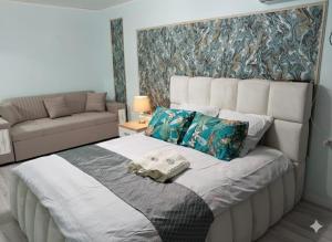 Bett in einem Zimmer mit einem Sofa und einem Bett sidx sidx sidx sidx in der Unterkunft Уютная 1 комнатная квартира в самом центре Шымкента in Zhezdi