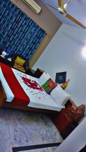 een slaapkamer met een bed met een rood-wit dekbed bij RESIDENCY GUEST HOUSE University Town Peshawer in Peshawar