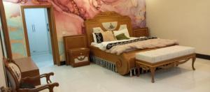 een slaapkamer met een bed met een schilderij aan de muur bij RESIDENCY GUEST HOUSE University Town Peshawer in Peshawar