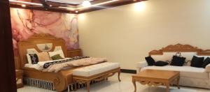 een kamer met twee bedden en een tafel erin bij RESIDENCY GUEST HOUSE University Town Peshawer in Peshawar