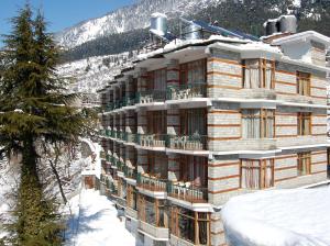Un edificio nella neve su una montagna di Lords Residency a Manāli