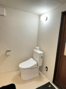 a bathroom with a toilet with a light on the wall at Foresta Karuizawa 6 "Glamping & Tent" for 8 people in Karuizawa