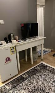 a white desk with a computer on it next to a refrigerator at غرفة الجوري 2 الباب الذكي in Dammam