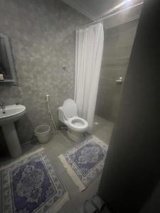 a bathroom with a toilet and a shower and a sink at غرفة الجوري 2 الباب الذكي in Dammam