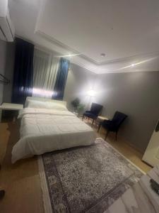 a bedroom with a bed and a table and chairs at غرفة الجوري 2 الباب الذكي in Dammam