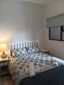 a bedroom with a bed with towels on it at Tide's Edge in Kleinbaai