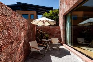 eine Terrasse mit zwei Stühlen und einem Sonnenschirm in der Unterkunft Mucheng Xichi Snow Mountain Art Resort Hotel (Baisha Ancient Town Branch) in Lijiang