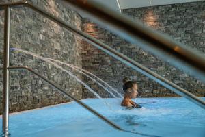 a woman in a hot tub with a fountain at La Val Hotel & Spa in Breil/Brigels