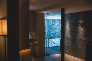a glass door leading into a room with a staircase at La Val Hotel & Spa in Breil/Brigels