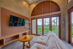 乌布The Kanndra Villa Ubud的客厅里有一张沙发和一台电视