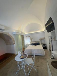 a bedroom with a bed and a table and chairs at Nivèra White Allure Maison in Ostuni