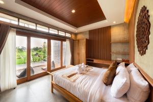 乌布The Kanndra Villa Ubud的一间卧室，配有一张大床和一扇大窗户。