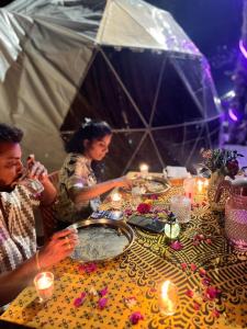 a group of people sitting at a table with candles at Kodai paradise in Dindigul +4 photos