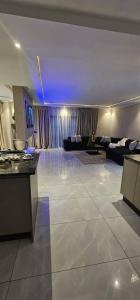 ein großes Wohnzimmer mit Couch und Tisch in der Unterkunft Villa De Luna in Avondale, Lomagundi Road in Tudeley