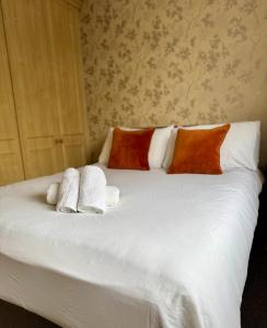 a bed with white sheets and pillows on it at Spacious House Parking Pool Table in Balderton +4 photos