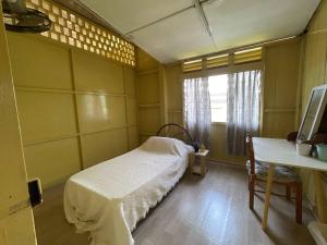 une chambre avec un lit, une table et une fenêtre dans l'établissement Rooma Rustic Homestay, à Kuala Kangsar