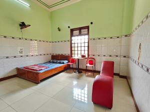 ein Schlafzimmer mit einem Bett, einem Tisch und einem Stuhl in der Unterkunft Nhà Nghỉ Mỹ Linh - Quảng Ngãi in Mỹ Lộc