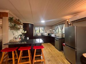 a kitchen with a counter and red stools in it at Erdvarkie at Kruger, Marloth Park in Marloth Park