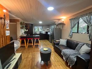 a living room with a couch and a kitchen at Erdvarkie at Kruger, Marloth Park in Marloth Park