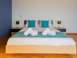 a bedroom with a large bed with blue and white pillows at Skyline Villas Top in Arco da Calheta