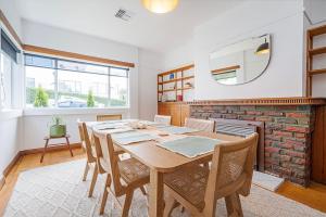 a dining room with a table and chairs and a fireplace at 1950 Serenity - Classic Hobart Escape near CBD in West Hobart