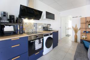 a kitchen with a washing machine and a microwave at Logis de la Trinité - Appt climatisé in Mauléon +7 photos