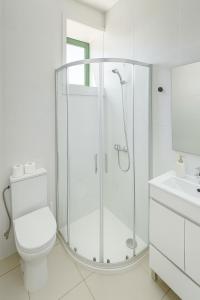 a white bathroom with a shower and a toilet at Douro Vila 10 - Best View in Town in Bandeira