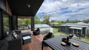a patio with a couch and a table on a deck at Slice of paradise in Haumoana