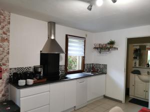 a kitchen with white cabinets and a window at Home nature in Nantes
