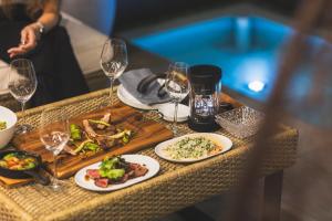 a table with plates of food and wine glasses at BLUE BLACK blue black in Karatsu