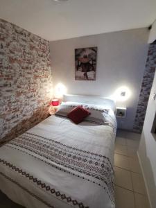 a bedroom with a bed with a brick wall at Home nature in Nantes