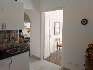 a kitchen with a sink and a door to a dining room at Eos Lipari in Lipari