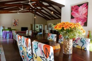a dining room with chairs and a table with a vase of flowers at Hluhluwe Homestead in Hluhluwe