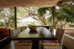 a wooden table with chairs and a bowl on top at Hluhluwe Homestead in Hluhluwe