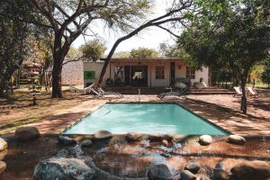 a swimming pool in front of a house at Hluhluwe Homestead in Hluhluwe