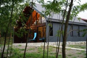 a house with large glass windows on the side of it at Banoja Twins in Kutaisi