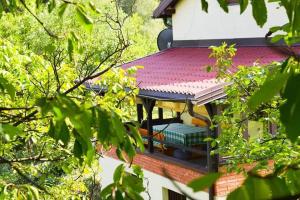 a building with a red roof with a green bench at Dream weekend house in Visoko
