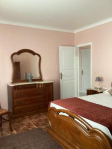 a bedroom with a bed and a mirror and a dresser at Casa das Cales - Grande in Altares +13 photos