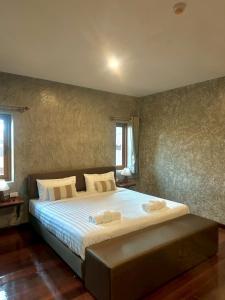 a bedroom with a large bed with two towels on it at Momento House in Phra Nakhon Si Ayutthaya