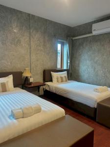 a hotel room with two beds and a table at Momento House in Phra Nakhon Si Ayutthaya