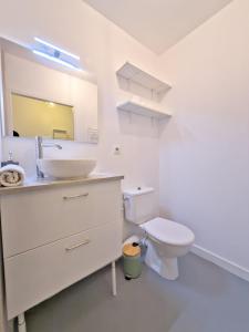 a white bathroom with a sink and a toilet at L'Acacia in Aytré +13 photos