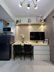 a kitchen with a desk with two chairs and a television at Blisshaven SHORE 2 B03-14100 in Sampong